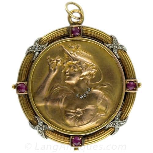 Art Nouveau Diamond, Ruby & Gold Medal Jewel Depicting a Woman with Flowing Hair.