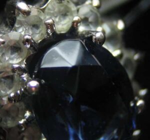 Example of a Paste Sapphire Imitation. Notice the Rounded Facet Edges Which Tell Us the Stone Wasn't Cut, but Cast into a Model. Photo by JB.