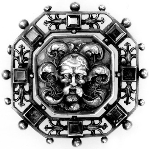 Cast and Chased Oxidised Silver Brooch of Octagonal Form, the Openwork Border Set with Eight Square-Cut Garnets, with a Grotesque Mask Surrounded by Foliage in the Centre. 1870 (circa) © The Trustees of the British Museum.