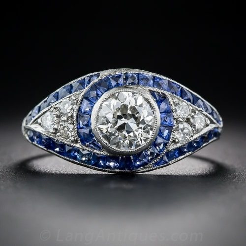 Art Deco Diamond and Platinum Engagement Ring with Swirls of French-Cut Sapphire Outlines and Millegrained Edges.