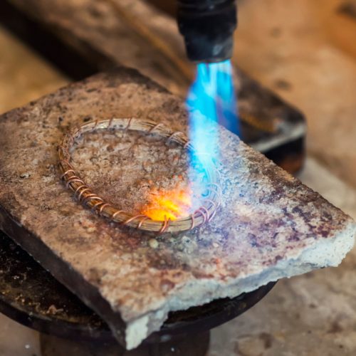 Jeweler Using a Torch to Anneal a Coil of Wire. Jeweler Using a Torch to Anneal a Coil of Wire.